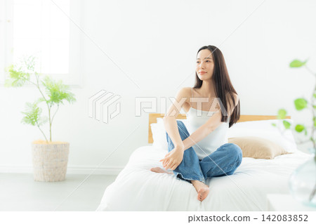 A woman relaxing in the bedroom A woman relaxing in the bedroom 142083852