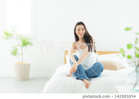 A woman relaxing in the bedroom A woman relaxing in the bedroom 142083854