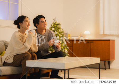 聖誕節當天,一對夫婦在客廳放鬆休息。 聖誕節當天,一對夫婦在客廳放鬆休息。 142083946