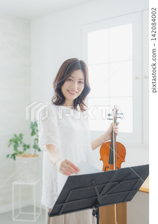 一位女士在家練習小提琴。 一位女士在家練習小提琴。 142084002