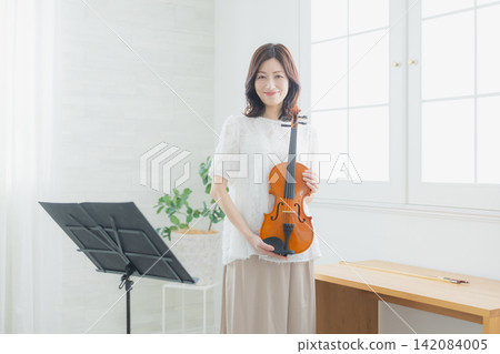 一位女士在家練習小提琴。 142084005