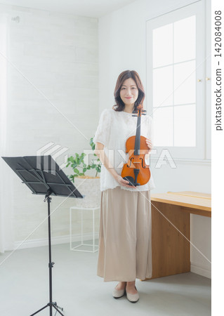 一位女士在家練習小提琴。 142084008