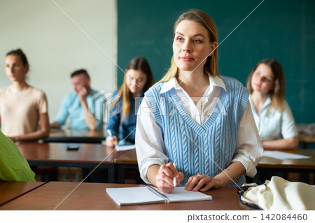 Portrait of a girl student writing a lecture synopsis Portrait of a girl student writing a lecture synopsis 142084460