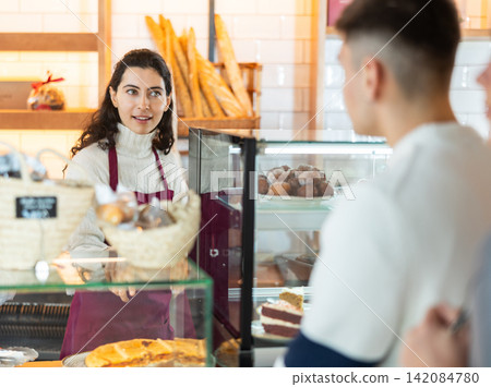 Woman seller offering pastries and coffee Woman seller offering pastries and coffee 142084780