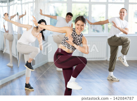 Team of dancers performing contemporary dance in choreography studio Team of dancers performing contemporary dance in choreography studio 142084787