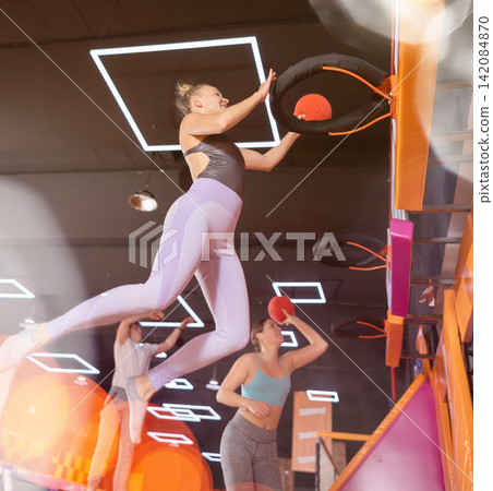 Adult woman playing ball in trampoline center Adult woman playing ball in trampoline center 142084870