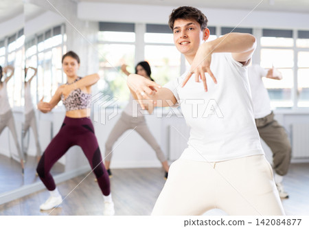 Guy enjoys active dancing, learns new movements, moves synchronously with participants of lesson Guy enjoys active dancing, learns new movements, moves synchronously with participants of lesson 142084877