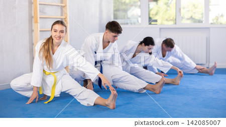 Group of people doing stretching in studio Group of people doing stretching in studio 142085007