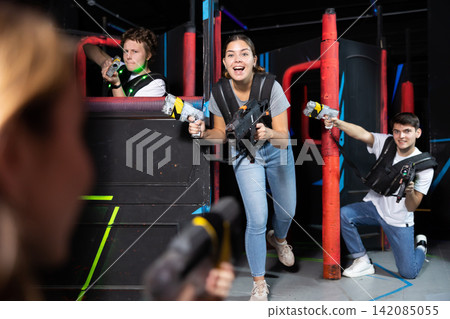 Three people playing lasertag in arena Three people playing lasertag in arena 142085055