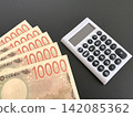 Five 10,000 yen bills and a white calculator (with a black background) 142085362