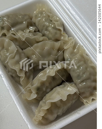 Steamed or fried mandu dumplings served alongside fermented kimchi, creating a classic Korean pairing that combines savory, tender dumplings with spicy, tangy, and flavorful fermented vegetables Steamed or fried mandu dumplings served alongside fermented kimchi, creating a classic Korean pairing that combines savory, tender dumplings with spicy, tangy, and flavorful fermented vegetables 142085644