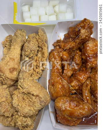 Crispy Korean fried chicken, perfectly glazed with a sweet and spicy sauce. Ideal for food photography and menus, showcasing the irresistible crunch and flavor of this beloved dish. Crispy Korean fried chicken, perfectly glazed with a sweet and spicy sauce. Ideal for food photography and menus, showcasing the irresistible crunch and flavor of this beloved dish. 142085661