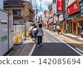 Pedestrians walking along Sakae Dohri dining street on a sunny summer day in Takadanobaba, Tokyo, Japan 142085694