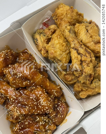 Crispy Korean fried chicken, perfectly glazed with a sweet and spicy sauce. Ideal for food photography and menus, showcasing the irresistible crunch and flavor of this beloved dish. Crispy Korean fried chicken, perfectly glazed with a sweet and spicy sauce. Ideal for food photography and menus, showcasing the irresistible crunch and flavor of this beloved dish. 142085748
