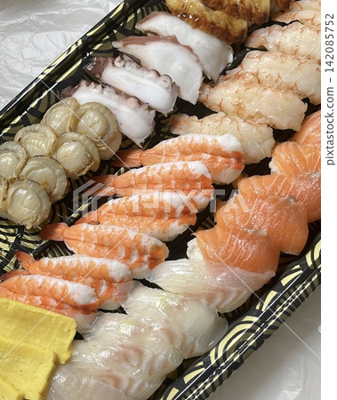 An assortment of fresh sushi, artfully arranged with a variety of toppings and vibrant colors. This traditional Japanese dish combines vinegared rice, seafood, and vegetables for an experience. An assortment of fresh sushi, artfully arranged with a variety of toppings and vibrant colors. This traditional Japanese dish combines vinegared rice, seafood, and vegetables for an experience. 142085752