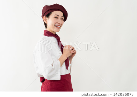 A woman wearing a baker's uniform A woman wearing a baker's uniform 142086073