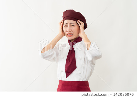 A woman wearing a baker's uniform 142086076