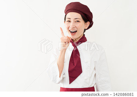 A woman wearing a baker's uniform A woman wearing a baker's uniform 142086081