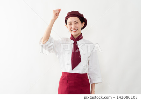 A woman wearing a baker's uniform 142086105