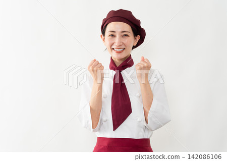 A woman wearing a baker's uniform A woman wearing a baker's uniform 142086106