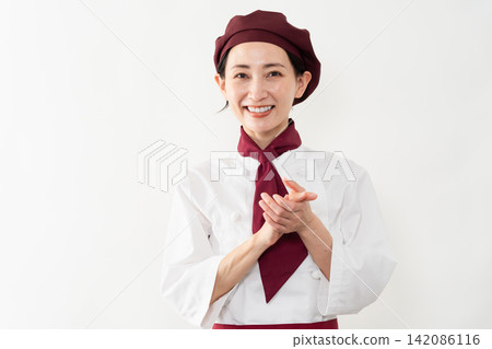 A woman wearing a baker's uniform A woman wearing a baker's uniform 142086116
