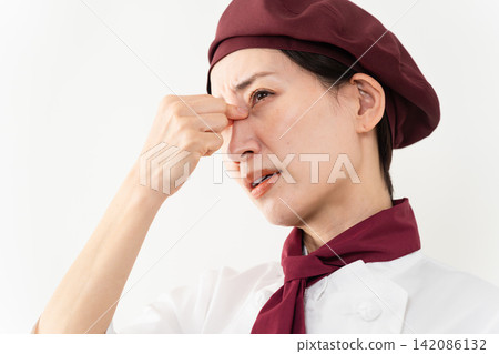 A woman wearing a baker's uniform 142086132