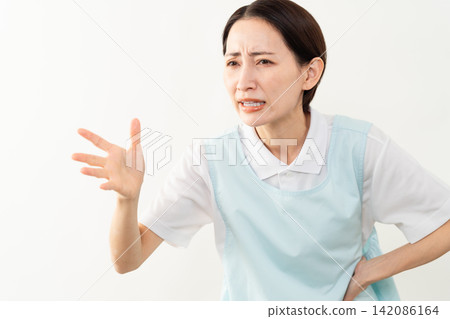 A woman wearing a light blue apron; a caregiver image. A woman wearing a light blue apron; a caregiver image. 142086164