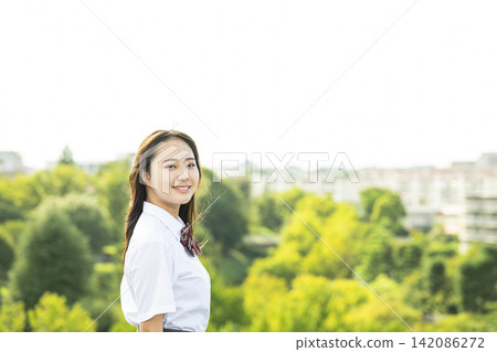 一名高中女生站在屋頂上,直視鏡頭。 一名高中女生站在屋頂上,直視鏡頭。 142086272