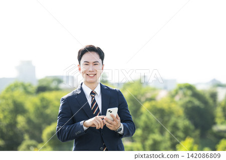 A businessman with a smartphone A businessman with a smartphone 142086809