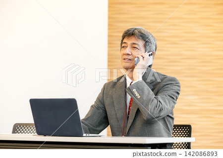 一位身穿西裝的老者正在打電話 一位身穿西裝的老者正在打電話 142086893