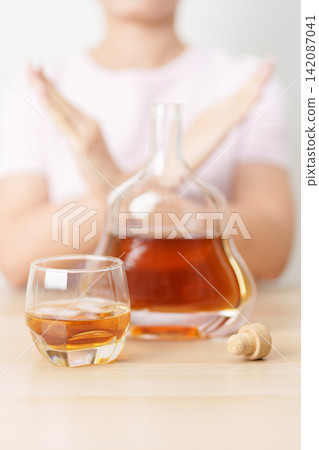 woman making stop hand gesture to refuse a glass of Cognac, Healthy man say no to alcohol drink, stop alcoholism and addiction concept. Responsible man reject a drink before driving and quit booze woman making stop hand gesture to refuse a glass of Cognac, Healthy man say no to alcohol drink, stop alcoholism and addiction concept. Responsible man reject a drink before driving and quit booze 142087041
