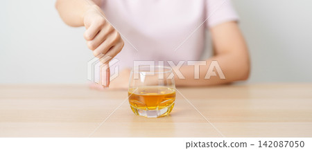 woman show thumb down hand gesture to refuse a glass of whisky, Healthy man say no to alcohol drink, stop alcoholism and addiction concept. Responsible man reject a drink before driving and quit booze woman show thumb down hand gesture to refuse a glass of whisky, Healthy man say no to alcohol drink, stop alcoholism and addiction concept. Responsible man reject a drink before driving and quit booze 142087050