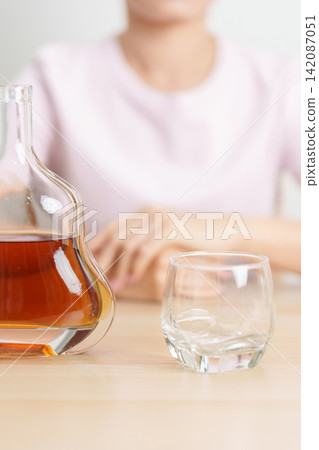 woman with glass of cognac on table, suffering from alcohol addiction and alcoholism concept. depicting emotional distress, depression, substance abuse problem, unhealthy lifestyle and mental health woman with glass of cognac on table, suffering from alcohol addiction and alcoholism concept. depicting emotional distress, depression, substance abuse problem, unhealthy lifestyle and mental health 142087051
