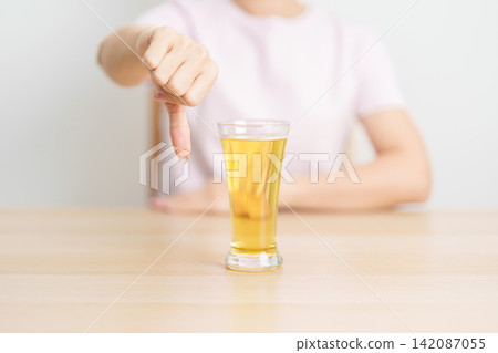 woman show thumb down hand gesture to refuse a glass of Beer, Healthy man say no to alcohol drink, stop alcoholism and addiction concept. Responsible man reject a drink before driving and quit booze woman show thumb down hand gesture to refuse a glass of Beer, Healthy man say no to alcohol drink, stop alcoholism and addiction concept. Responsible man reject a drink before driving and quit booze 142087055