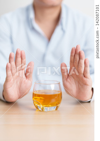 Man making stop hand gesture to refuse a glass of whiskey, Healthy man say no to alcohol drink, stop alcoholism and addiction concept. Responsible man reject a drink before driving and quit booze Man making stop hand gesture to refuse a glass of whiskey, Healthy man say no to alcohol drink, stop alcoholism and addiction concept. Responsible man reject a drink before driving and quit booze 142087101