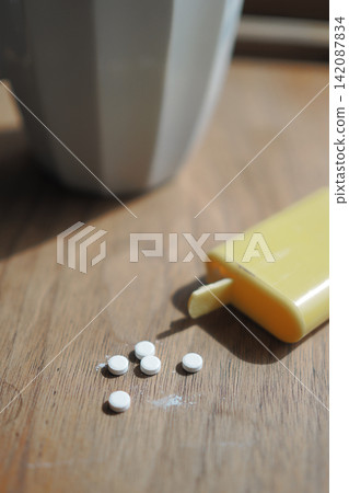 sweetener supplement and yellow container on wooden table near cup sweetener supplement and yellow container on wooden table near cup 142087834