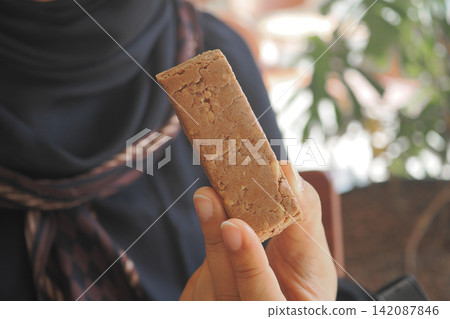 Person holds a sweet snack during a sunny day Person holds a sweet snack during a sunny day 142087846