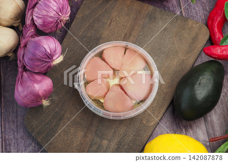 a container of canned tuna fillets arranged neatly in a circular plastic package a container of canned tuna fillets arranged neatly in a circular plastic package 142087878