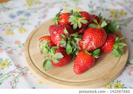 Strawberries on a plate with floral cloth backdrop Strawberries on a plate with floral cloth backdrop 142087880