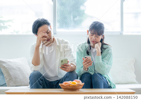 A couple arguing while looking at their smartphones A couple arguing while looking at their smartphones 142088150