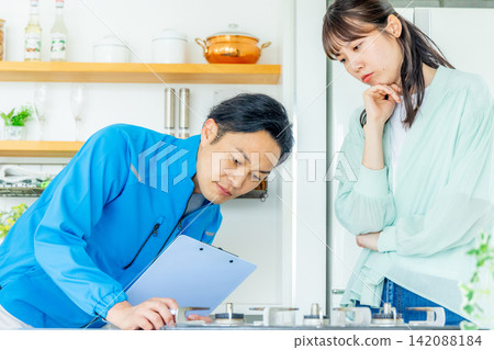 A woman in distress in the kitchen and a worker who came to inspect it. A woman in distress in the kitchen and a worker who came to inspect it. 142088184
