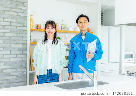 一位裝修承包商和一位家庭主婦站在廚房裡 142088191