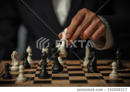 business hand holding white chess king taking black king, checkmate concept business hand holding white chess king taking black king, checkmate concept 142088317