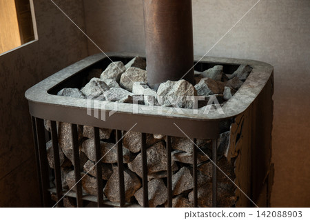 Sauna heater filled with neatly arranged stones providing heat source Sauna heater filled with neatly arranged stones providing heat source 142088903