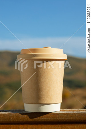 Warm beverage cup stands at a cozy outdoor setting 142088914