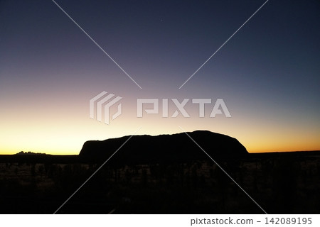 Silhouette of Uluru, viewed from a sunrise viewing area in Australia Silhouette of Uluru, viewed from a sunrise viewing area in Australia 142089195
