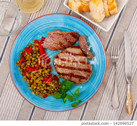 Fried beef served with peas and peppers Fried beef served with peas and peppers 142090527
