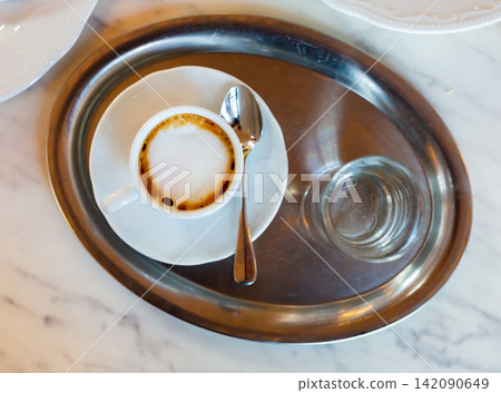 Cup of coffee served with glass of water Cup of coffee served with glass of water 142090649
