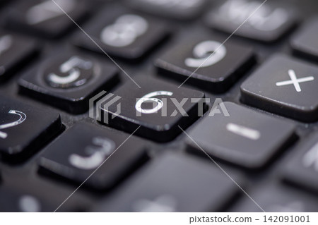 Close up view of black calculator number keys arithmetic symbols highlighting calculation finance accounting mathematics office technology 142091001