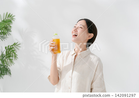 女人從一個塑料瓶喝茶 女人從一個塑料瓶喝茶 142091297